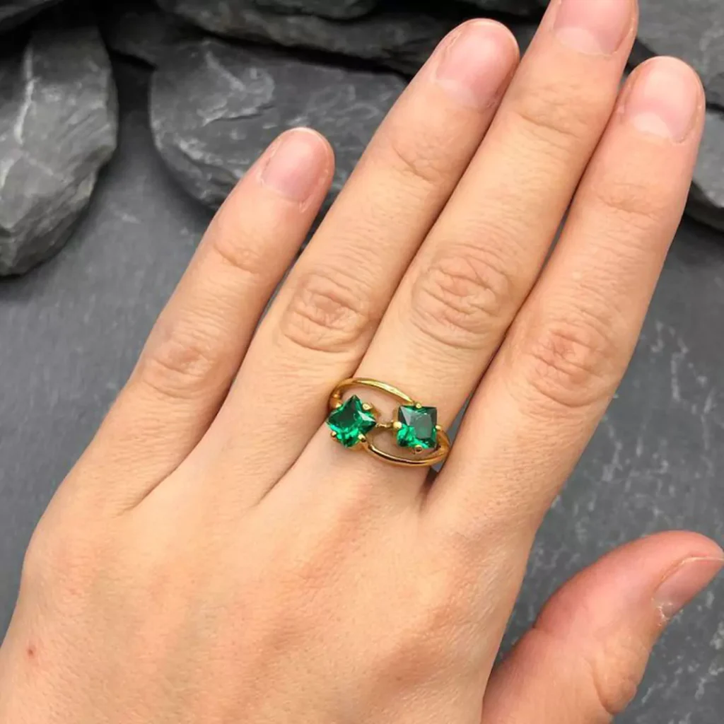 gleaming gold rings with square green gemstones 